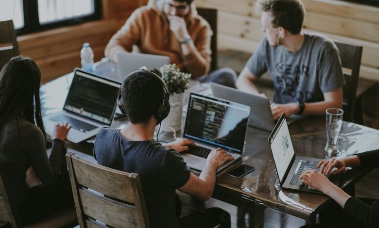 Colleagues collaborating around laptops in a modern office