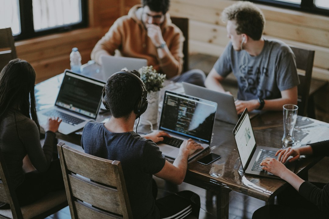 Colleagues collaborating around laptops in a modern office