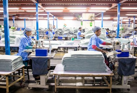 Workers sewing textiles inside a large garment factory