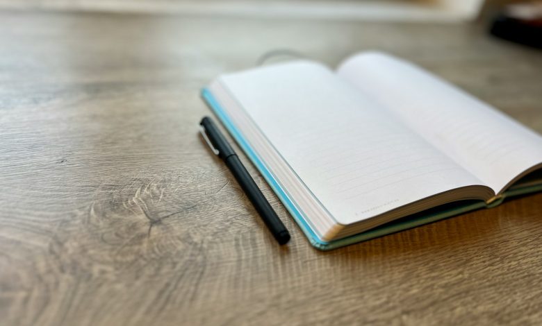 Pen and open notebook on a writer's desk.