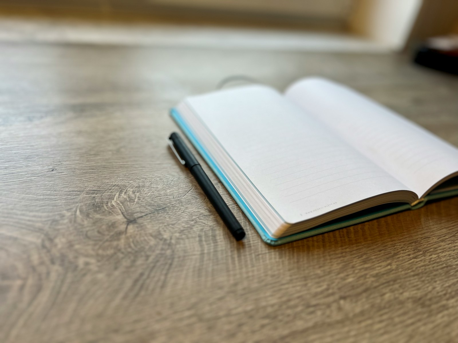 Pen and open notebook on a writer's desk.